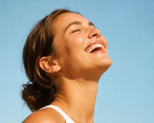 Mulher sorrindo sob um céu azul ensolarado